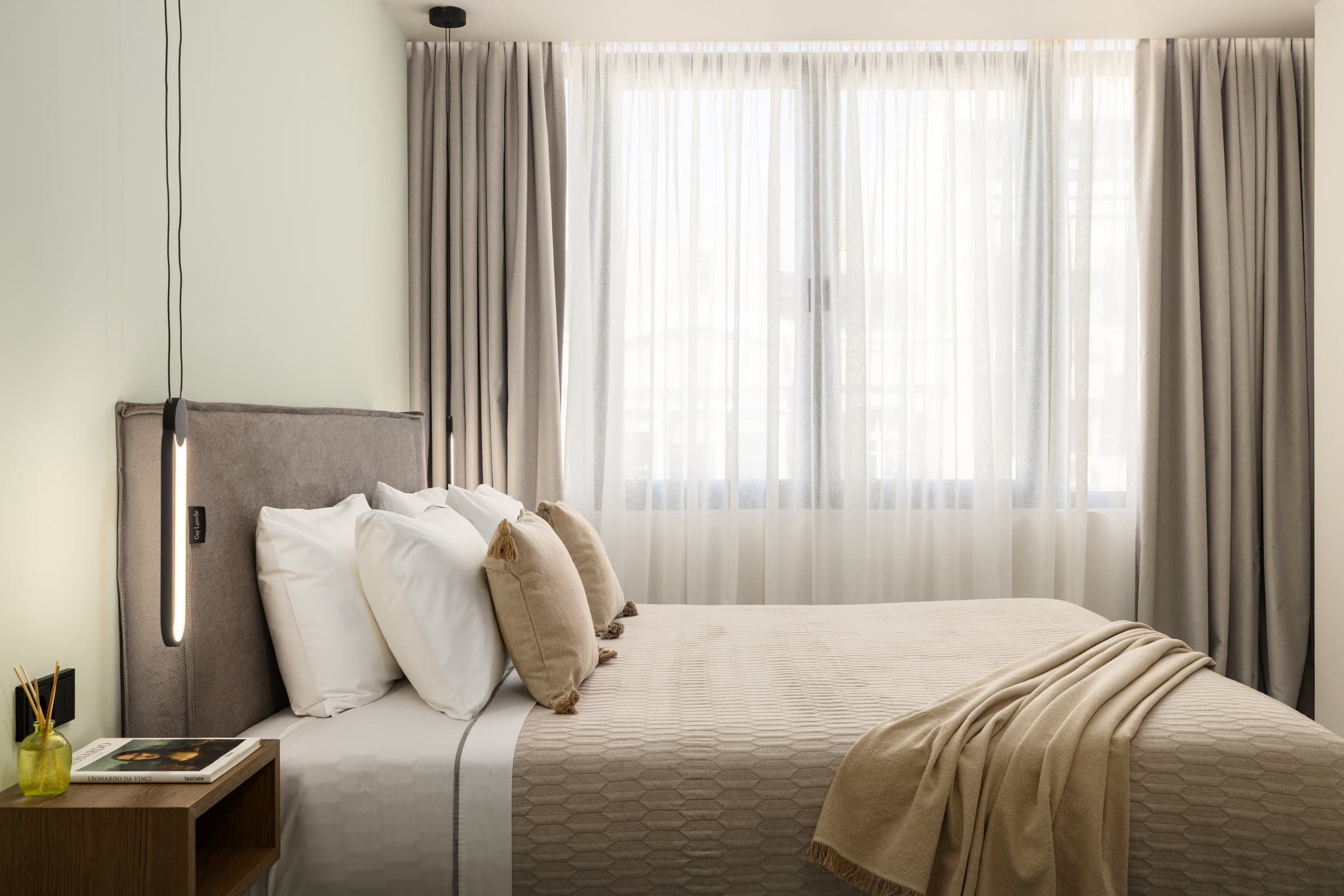 Queen-size κρεβάτι δίπλα σε μεγάλα παράθυρα στα Elit Urban Boutique Apartments